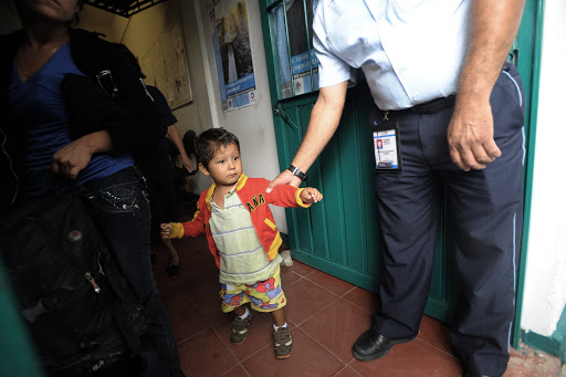 A Mexican immigration officer holds by his arm a child as he and his mother are deported back to Guatemala &#8211; es
