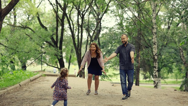 Mom-and-young-daughter-and-dad-a-young-family-on-a-walk-in-the-park-in-summer