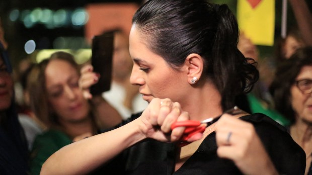 A-woman-cuts-her-hair-in-solidarity-with-Iranian-women-during-a-protest-against-the-death-of-Mahsa-Amini-AFP