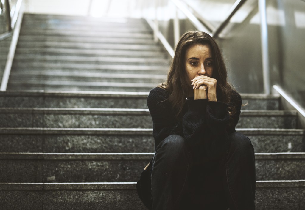 woman sitting on stairs looking worried