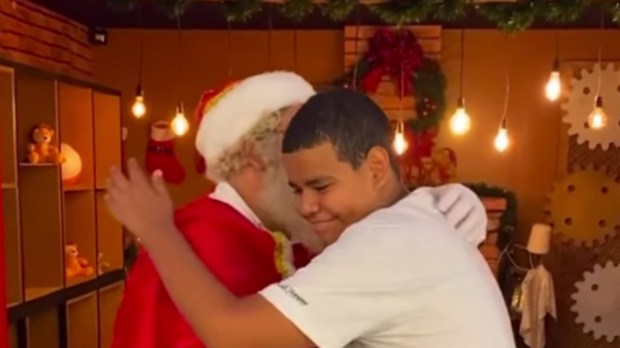 Papai Noel abraça jovem surdo