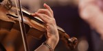 Mãos de uma mulher tocando violino