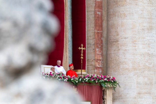 Pope Francis waves from the central loggia of St. Peter's basilica during the Easter 'Urbi et Orbi' message and blessing to the City and the World as part of the Holy Week celebrations