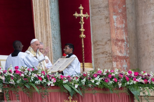 Pope Francis waves from the central loggia of St. Peter's basilica during the Easter 'Urbi et Orbi' message and blessing to the City and the World as part of the Holy Week celebrations