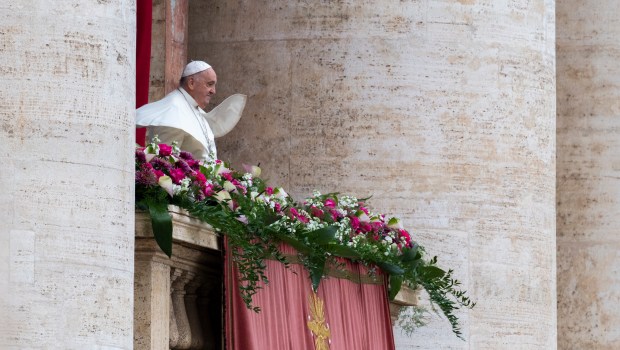 Pope Francis waves from the central loggia of St. Peter's basilica during the Easter 'Urbi et Orbi' message and blessing to the City and the World as part of the Holy Week celebrations