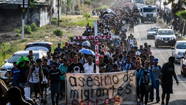 migrants carry a cross border between Mexico and the United States