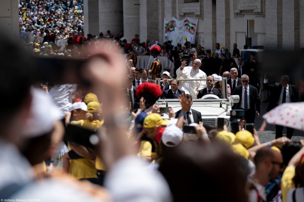 Pope Francis greets the crowd as he leaves after celebrating a mass on World Children's Day at St Peter's Basilica in the Vatican on May 26, 2024.