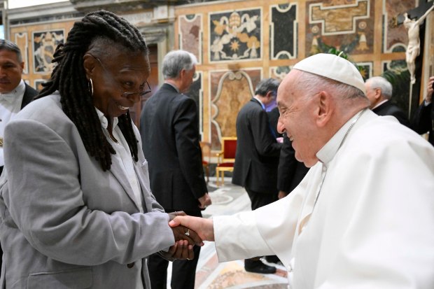 This photo taken and handout on June 14, 2024 by The Vatican Media shows Pope Francis shaking hand with US actress Whoopi Goldberg as part of an audience with comedians in The Vatican.