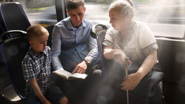 Joven evangelizando en el autobús